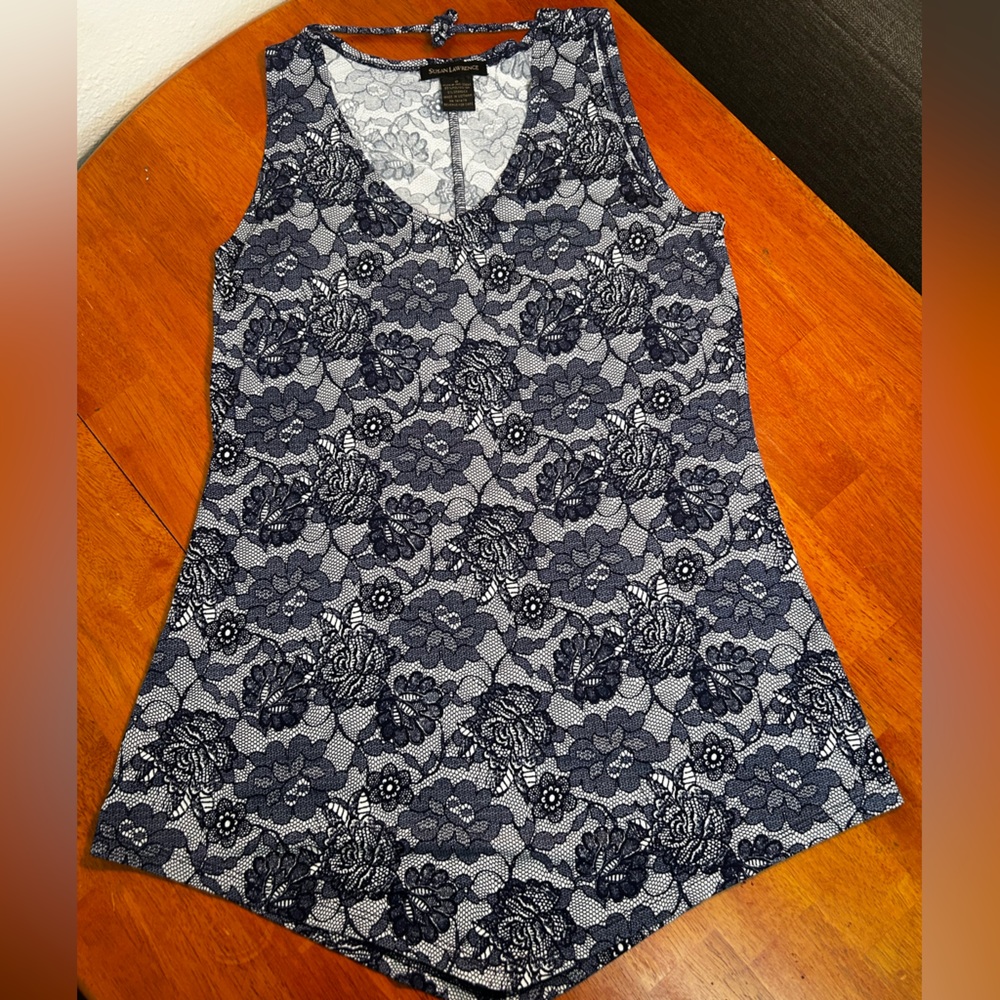 Sleeveless women’s top with blue floral lace pattern.
